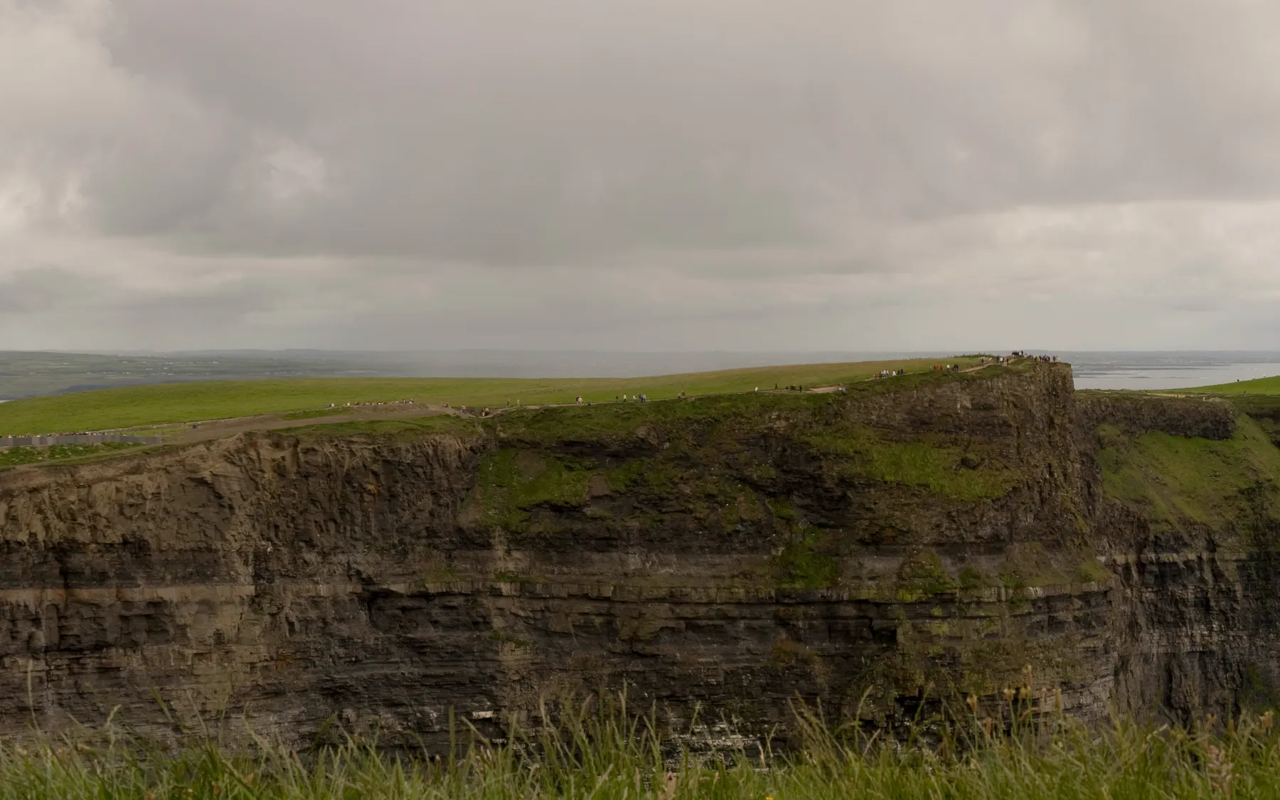 Green clifftops above the Atlantic at the Cliffs of Moher in County Clare