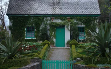 Stone cottage with green gate and door